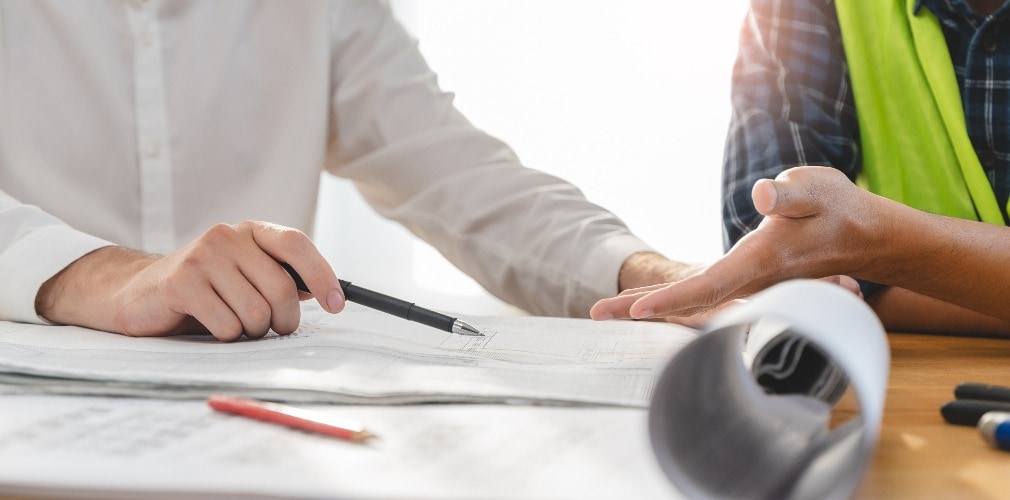 architect explaining client demand plan of construction on the table to contractor.